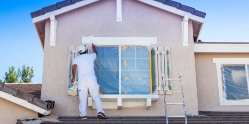 Busy House Painter Painting the Trim And Shutters of A Home.
